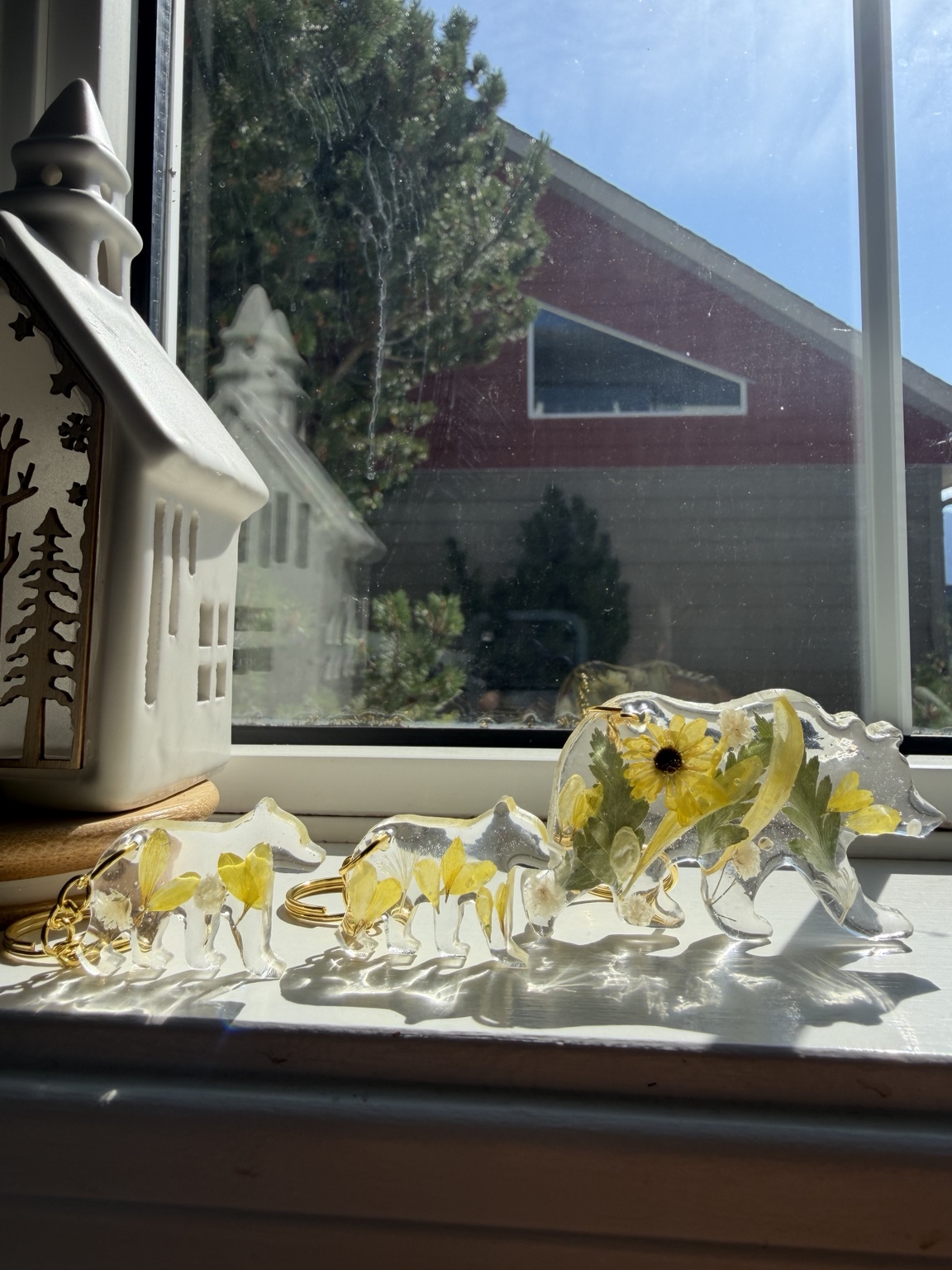 Yellow floral resin bear family on windowsill